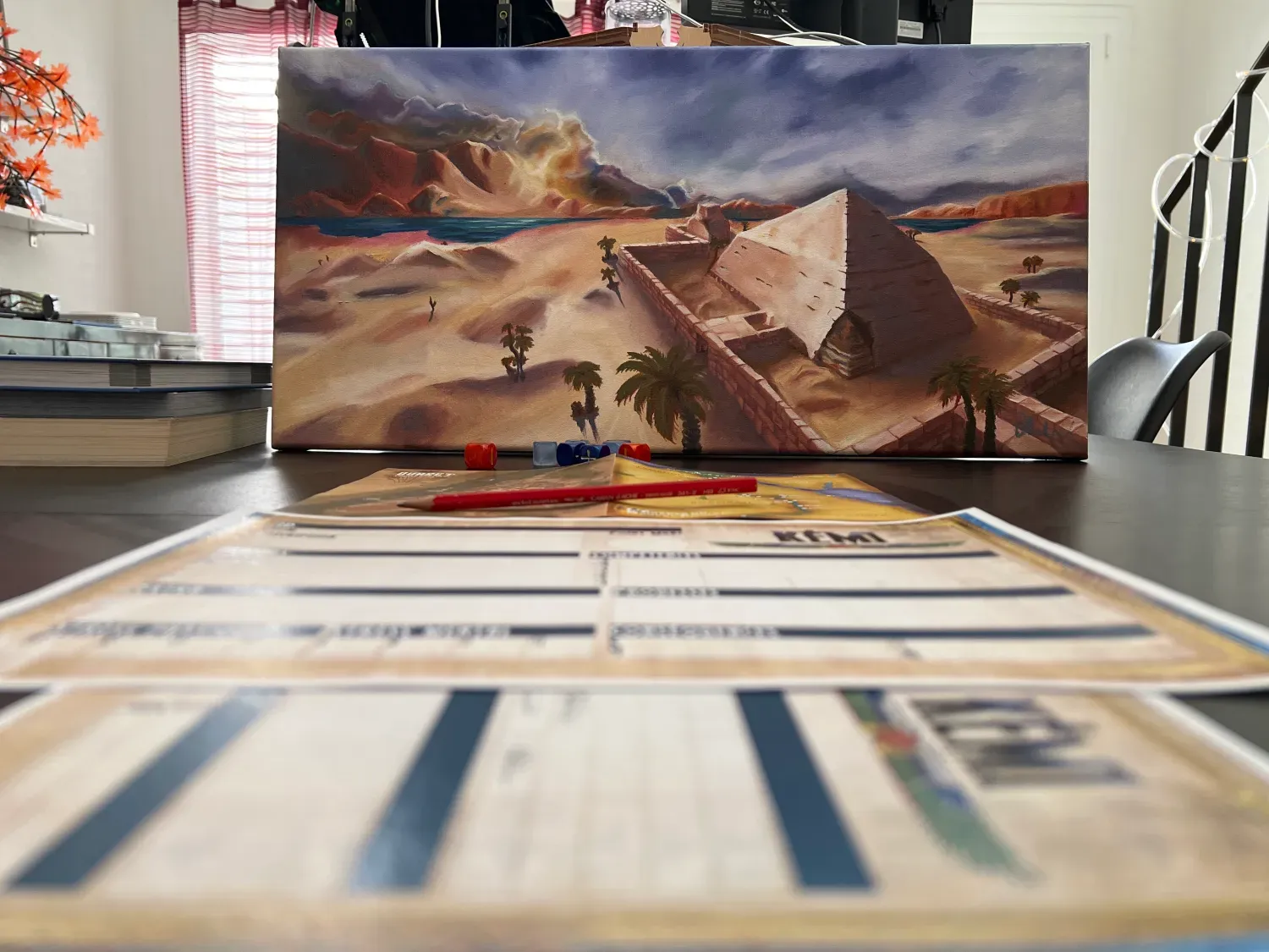 Une photo d'une peinture à l'huile représentant une pyramide, ainsi que les feuilles de personnages